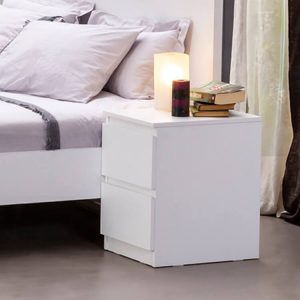 White 2-tier drawer nightstand table with candles and books on top