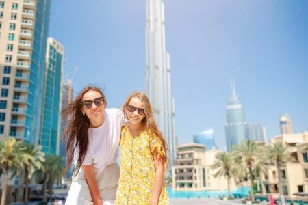 A woman and a girl posing in front of burj khalifa