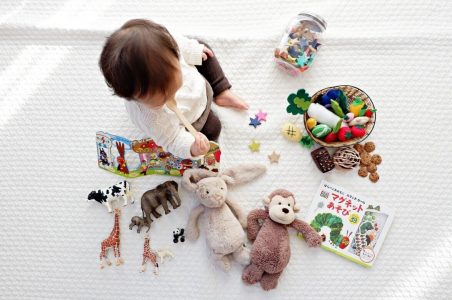 child sitting among toys